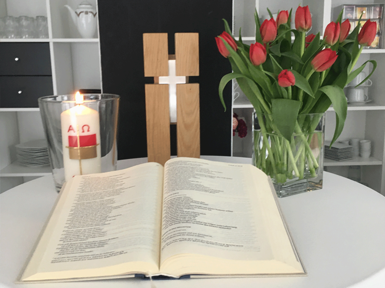 wertvoll-in-willich-aktuelles-gottesdienst cafe wert.voll in Willich, Foto für Gottesdienst, Kreuz, Kerze, offene Bibel und rote Tulpen in gemütlicher Atmosphäre