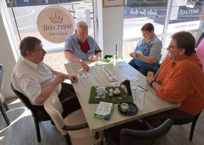 cafe wert.voll in Willich, Aktuelles "Spieleabend", gemütliche Atmosphäre, Menschen spielen Karten am Tisch